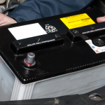 Man taking battery out of car