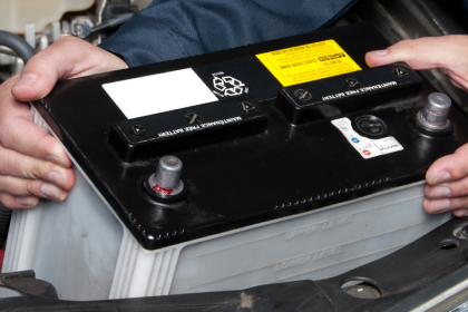 Man taking battery out of car